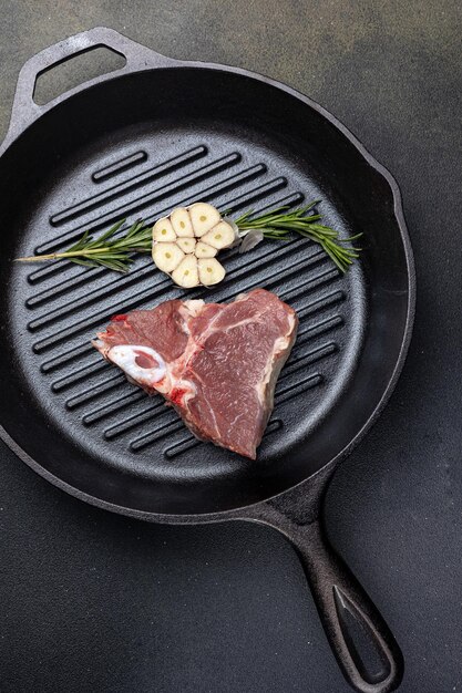 steak cru aux épices dans une poêle en fonte