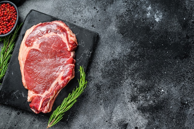 Steak cru frais avec des épices sur la table