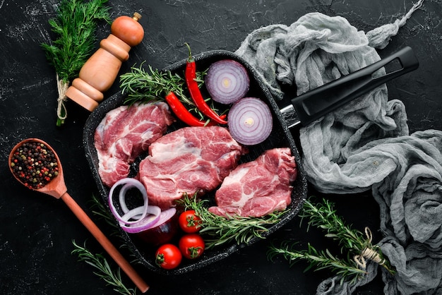 Steak cru Viande aux épices et herbes Sur fond de pierre noire Vue de dessus Espace de copie gratuit