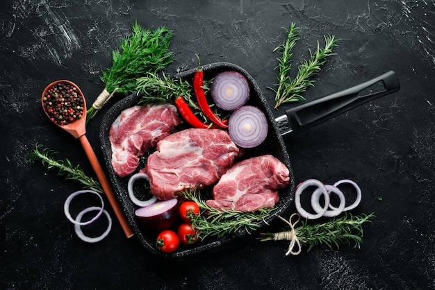 Steak cru Viande aux épices et herbes Sur fond de pierre noire Vue de dessus Espace de copie gratuit