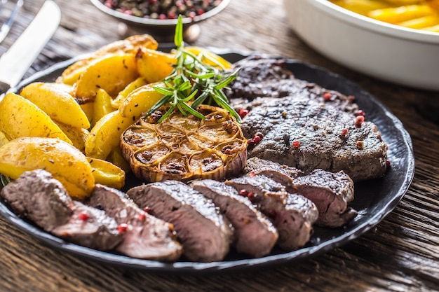 Steak de faux-filet de boeuf grillé avec pommes de terre américaines à l'ail sel romarin et épices.