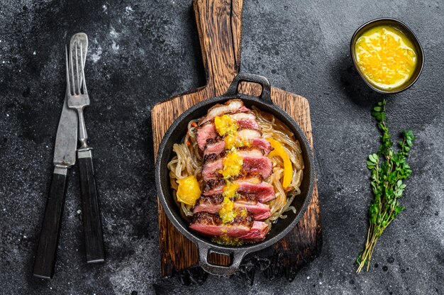 Steak de filet de poitrine de canard grillé avec nouilles et sauce aux mandarines.