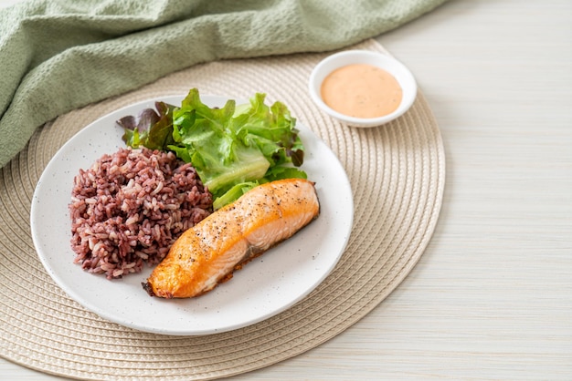 steak de filet de saumon grillé avec baies de riz et légumes - style d'aliments sains