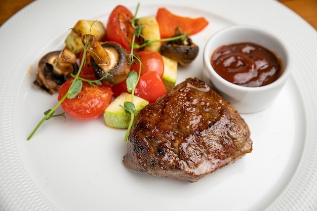 Steak avec garniture et sauce sur une assiette