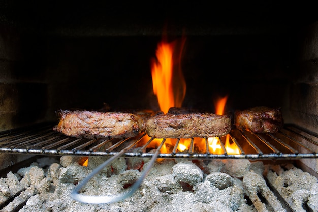 Photo steak sur le gril bbq et flammes