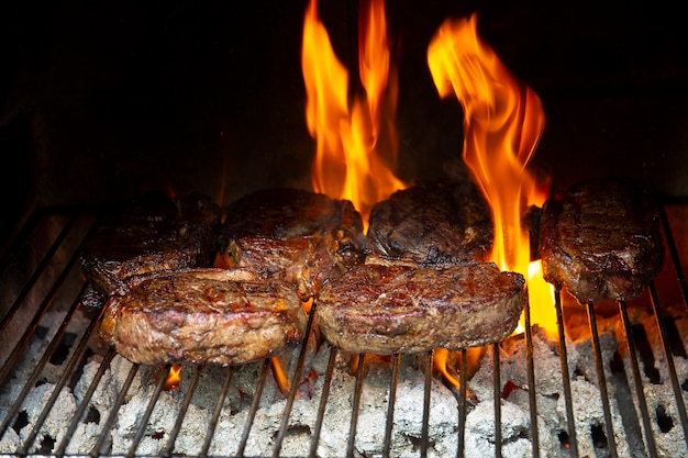 Photo steak sur le gril bbq et flammes