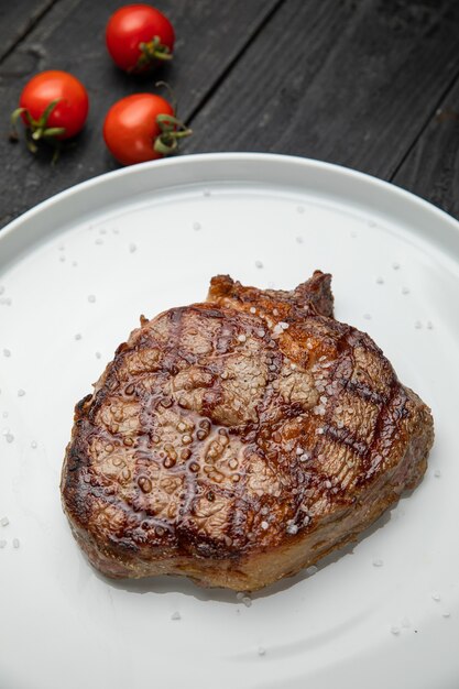 Steak grillé sur une assiette ronde blanche