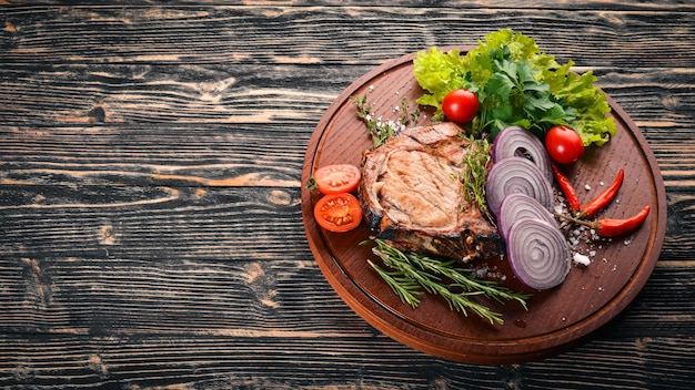 Steak Grillé, Aux Légumes. Porc, veau, viande. Sur un fond en bois. Vue de dessus. Espace libre pour le texte.