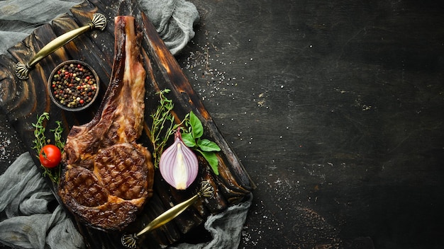 Steak grillé sur l'os herbes et épices sur un fond en bois Barbecue Vue de dessus Espace libre pour le texte