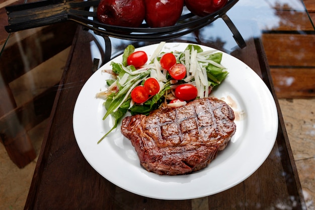 Steak grillé avec salade de tomates et laitue