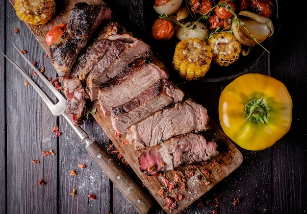 Steak grillé tranché sur une planche à découper.