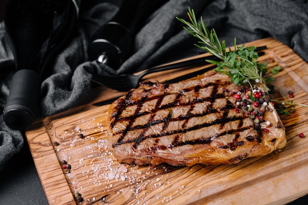 Steak grillé en tranches de contre-filet sur une planche à découper sur une table en pierre