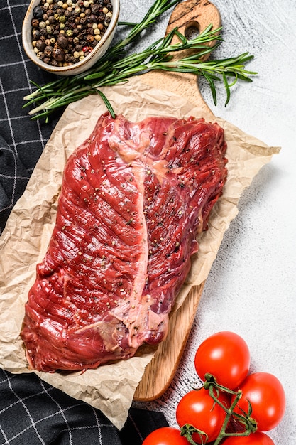 Steak de lame supérieur sur une planche à découper, viande crue, bœuf marbré.