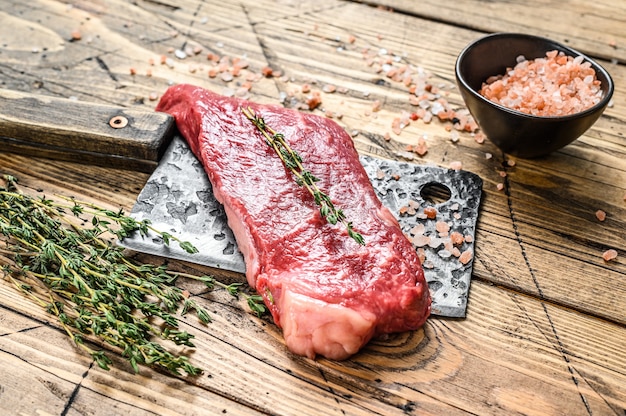 Steak de New York cru sur couperet, viande de bœuf.