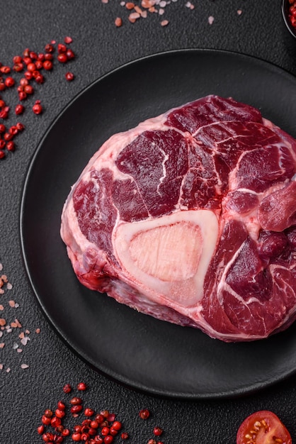 Steak d'ossobuco de bœuf frais avec épices et herbes salées sur fond de béton texturé