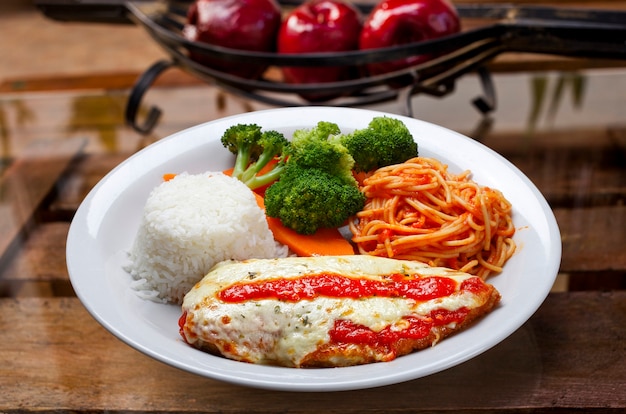 Steak parmigiana avec pâtes, riz et légumes