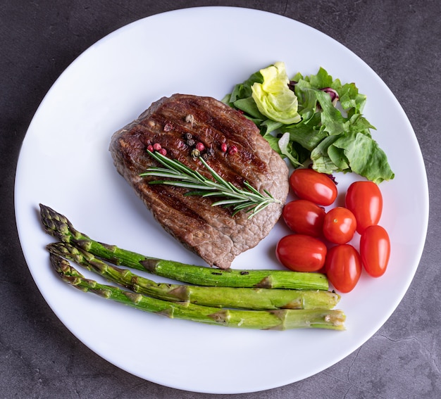 Steak sur une plaque blanche avec des légumes