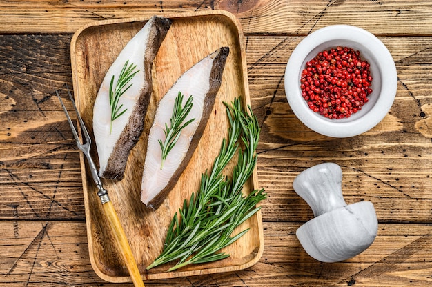 Steak de poisson d'eau salée de flétan cru. fond en bois. Vue de dessus.