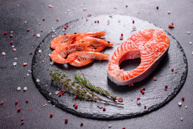 Steak de poisson rouge à la truite crue servi avec des herbes et du citron et de l'huile d'olive. Cuisson du saumon. Concept d'alimentation saine