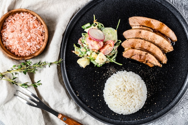 Steak de poitrine de dinde, volaille, accompagnement de riz et salade. Vue de dessus