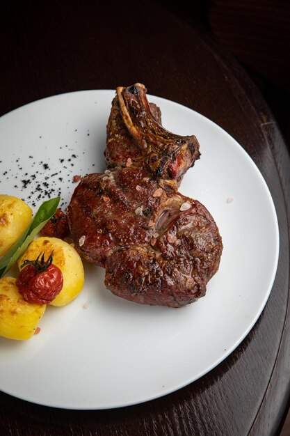 steak avec pommes de terre et cerises sur une assiette