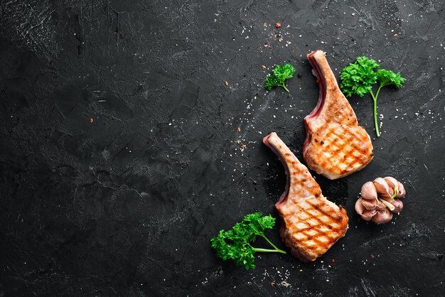 Steak de porc barbecue sur l'os avec des épices et des herbes Vue de dessus Espace libre pour votre texte