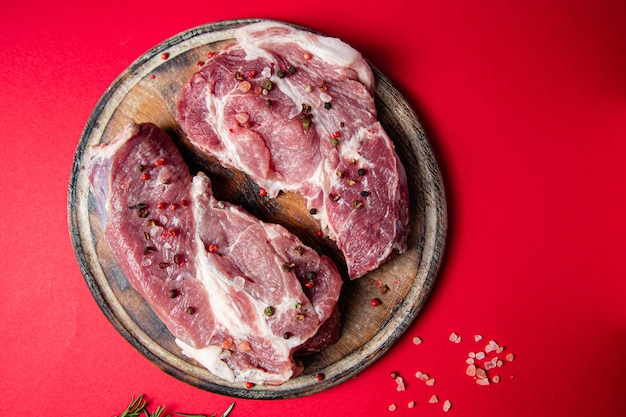 Steak de porc cru sur un gros plan de fond sombre