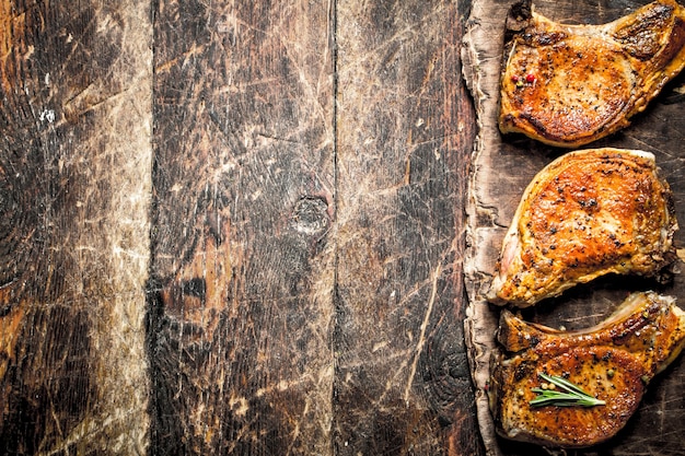 Steak de porc grillé aux épices. Sur fond en bois.