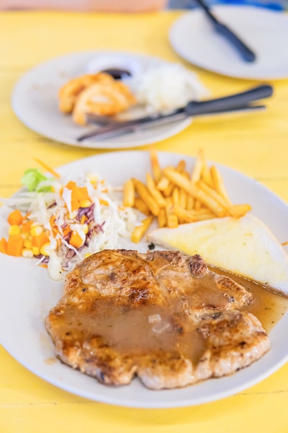 Steak de porc grillé avec frites sur plat