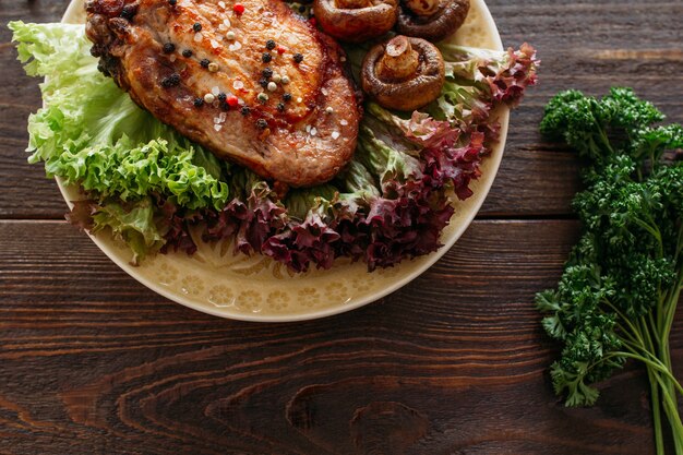 Steak de porc grillé avec laitue et champignons