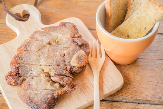 Steak de porc sur plaque de bois