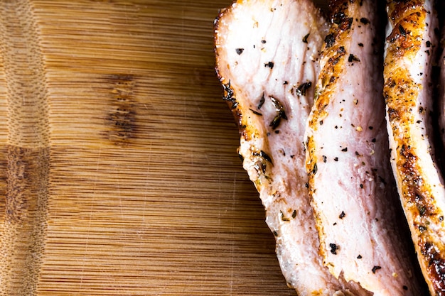 Steak de porc rôti sur une planche de bois et tranché