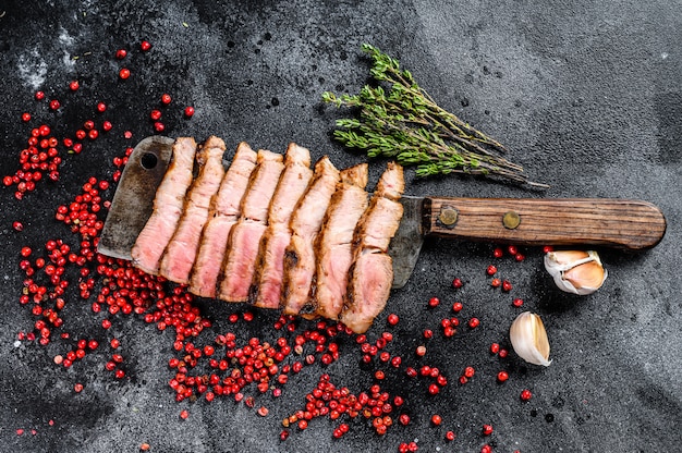 Steak de porc tranché grillé sur un couperet à viande