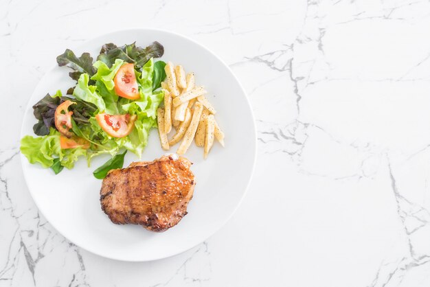 Photo steak de poulet grillé avec frites et salade de légumes