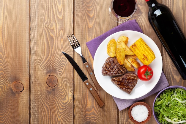 Steak avec salade de pommes de terre grillées et vin rouge