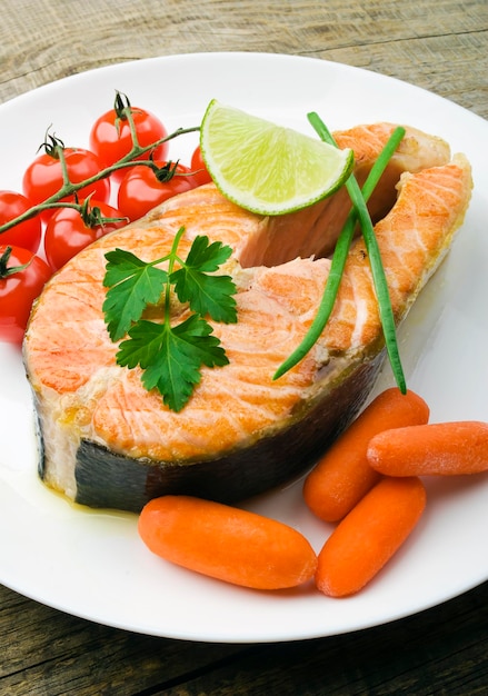 Steak de saumon aux légumes sur une plaque blanche