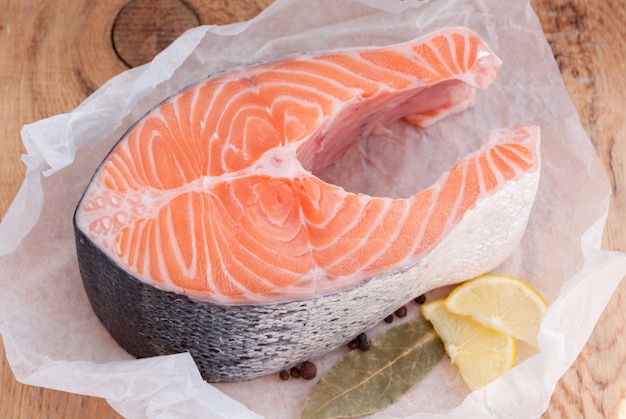 Steak de saumon cru poisson rouge et épices sur table en bois