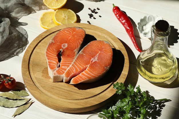 Steak de saumon frais avec des ingrédients sur fond de bois blanc