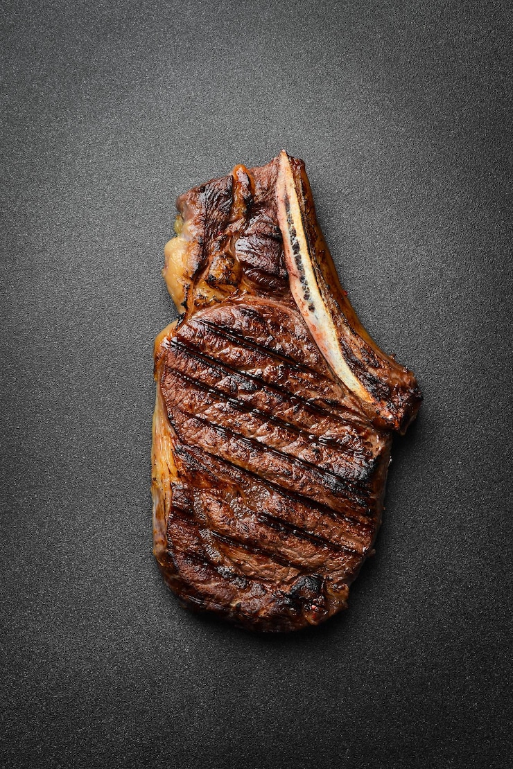 Photo steak steak grillé sur l'os morceau de viande rôtie espace libre pour le texte