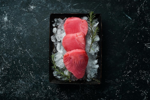 Steak de thon cru aux épices sur glace Sur fond sombre Vue de dessus