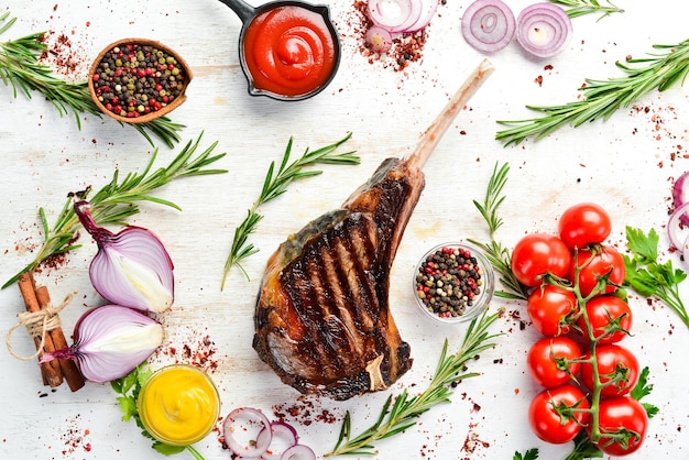 Steak Tomahawk sur l'os grillé au romarin et épices Vue de dessus Espace libre pour votre texte