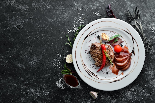 Steak de veau juteux au piment et poire sur une assiette. Vue de dessus. Espace de copie gratuit.