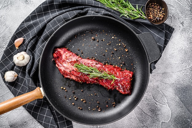 Steak de vega cru dans une poêle avec des ingrédients de cuisine. Vue de dessus