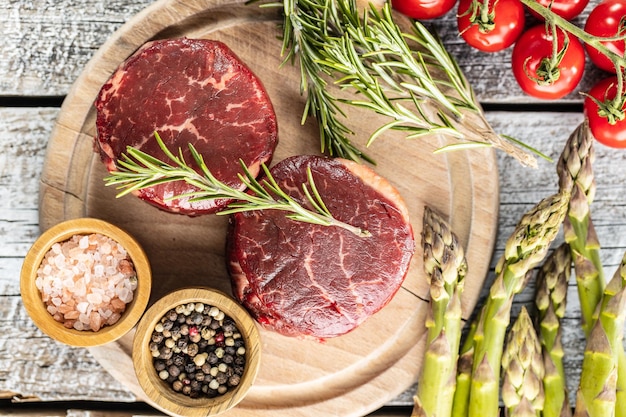 Le steak de viande de bœuf cru sur une planche à découper Vue de dessus