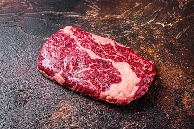 Steak de viande de bœuf de faux-filet cru sur une table de boucher préparé pour la cuisson