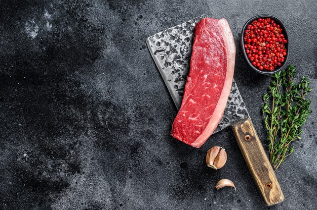 Photo steak de viande de bœuf de surlonge cru frais sur un couperet de boucher