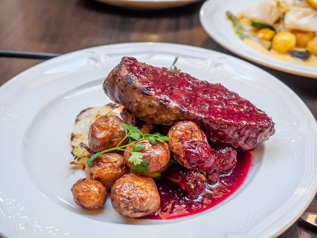 Steak de viande de cheval islandais avec boulette de viande avec sauce aux fruits rouges sur plat blanc au restaurant islandais