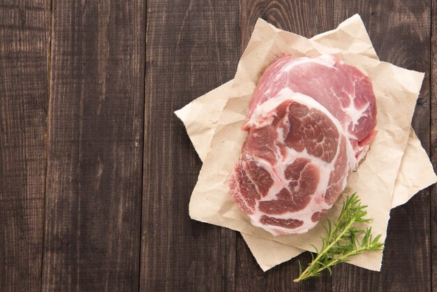 Steak de viande fraîche crue sur fond de bois