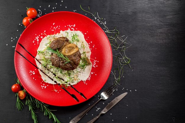 Steak de viande grillé sur feuille de pita dans une assiette rouge