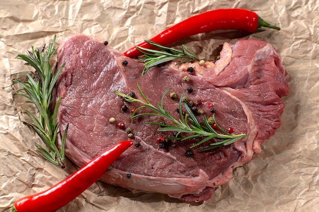 Steaks de boeuf cru sur un parchemin de cuisson avec des ingrédients pour la cuisson de la viande